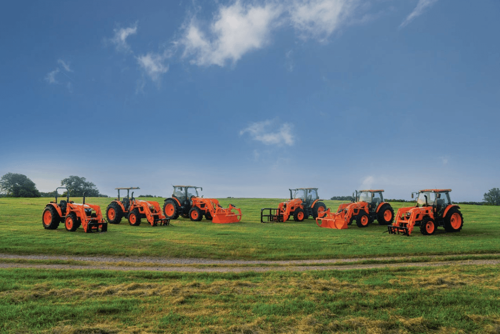 Kubota tractors lined up in a grass field
