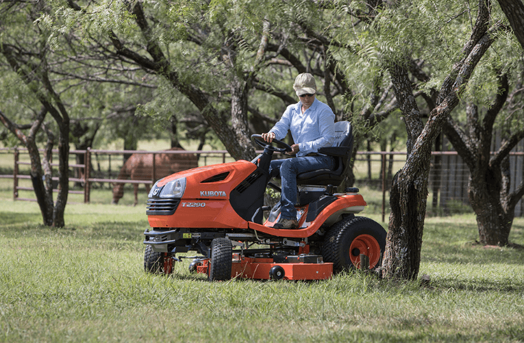 Operator maneuvering around trees with the lawn and garden tractor