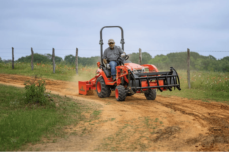 Man driving tractor down dirt road