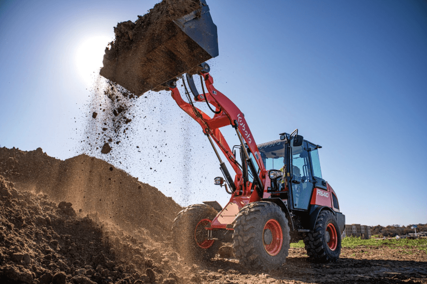 Loader dumping dirt onto pile