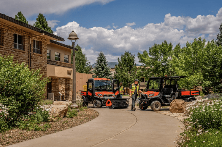 Two Kubota Utility Vehicles parked outside of a home
