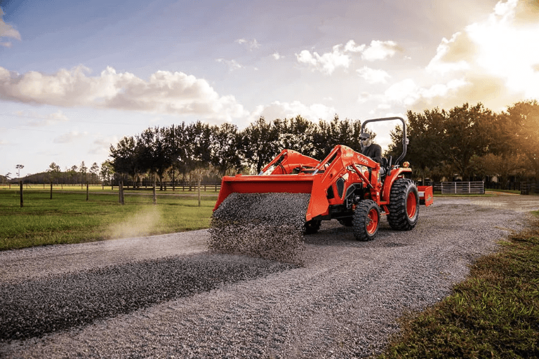 Front loader on tractor dumping gravel