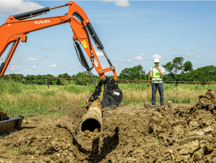 Excavator lifting up a pipe