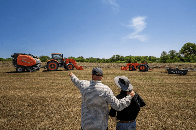 Men watching tractors pull hay balers