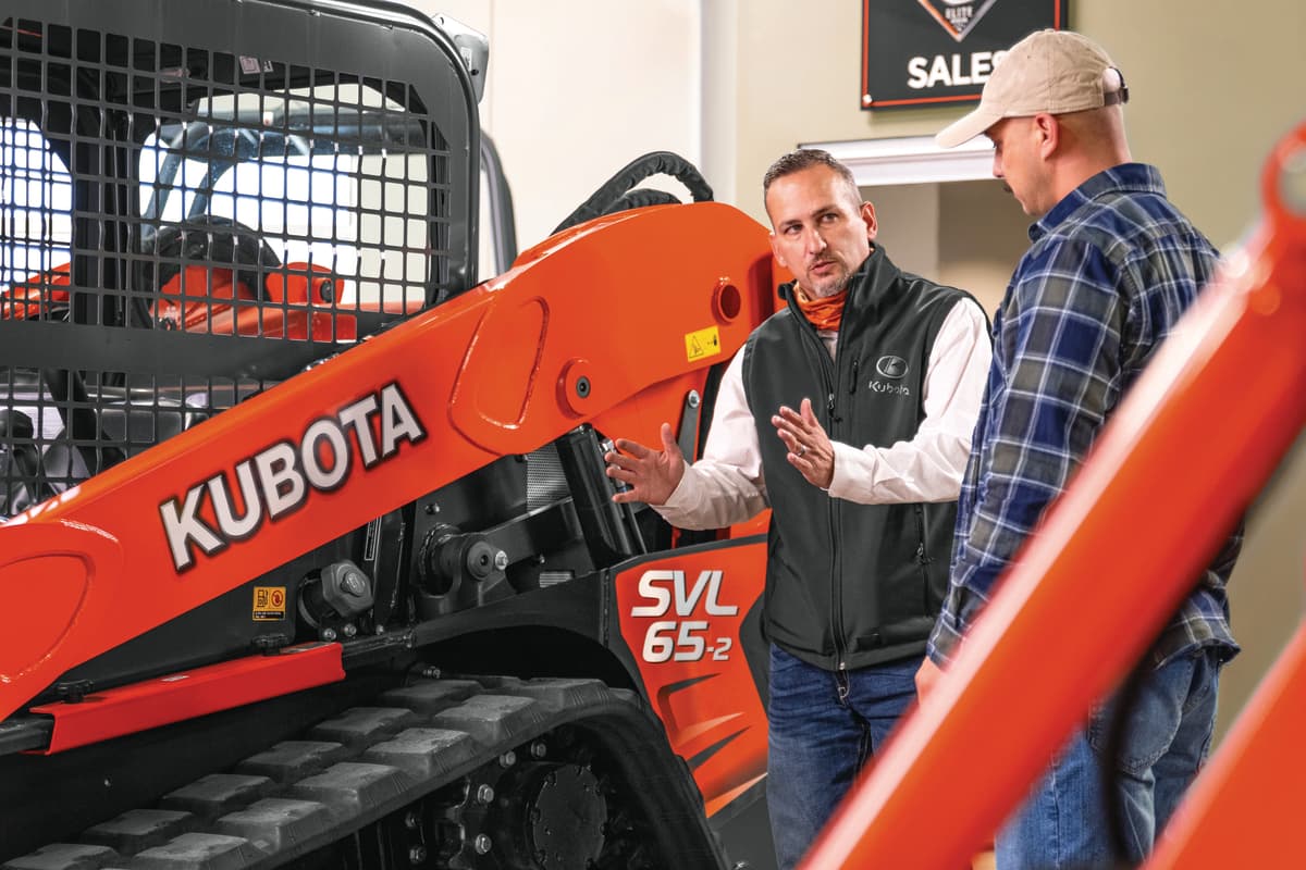 Sales staff and customer looking at a Kubota SVL65-2